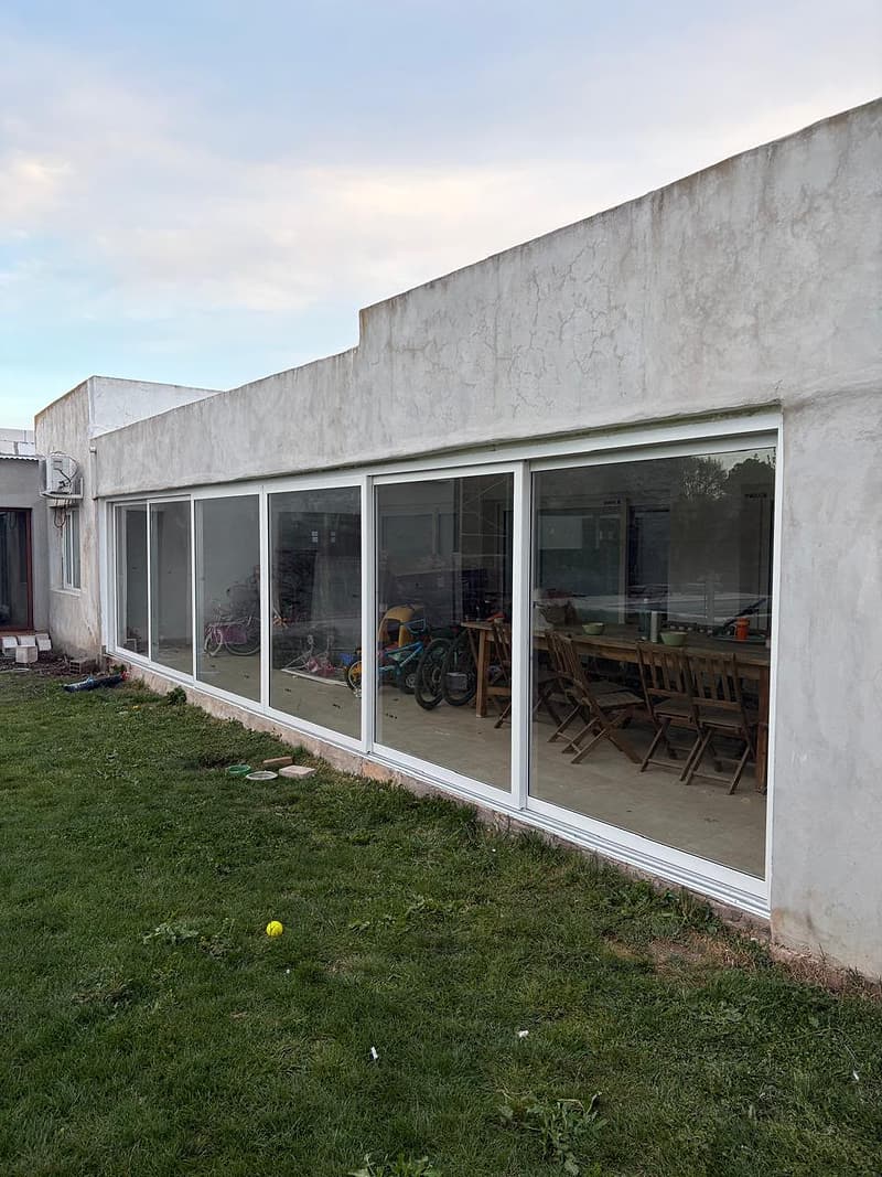 Galería con paños corredizos blancos de piso a techo