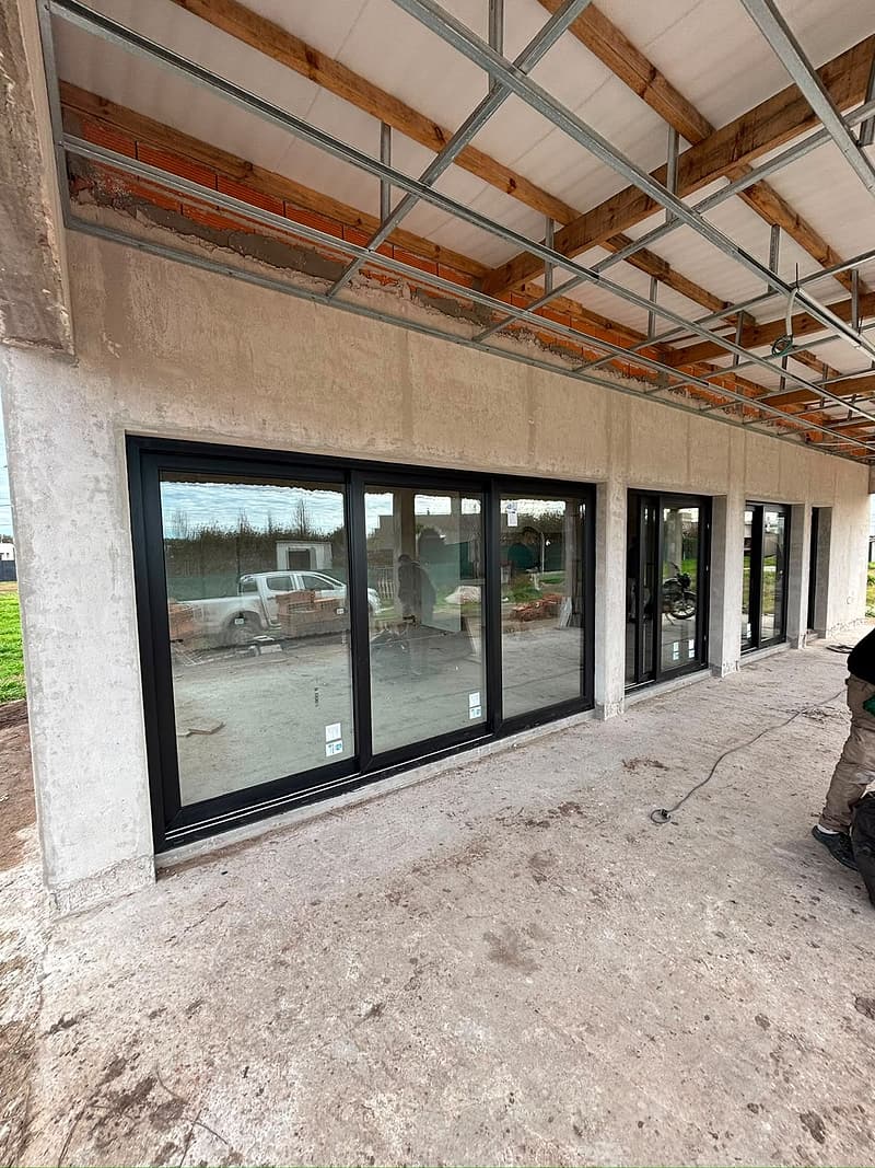 Frente con paños corredizos negros en obra