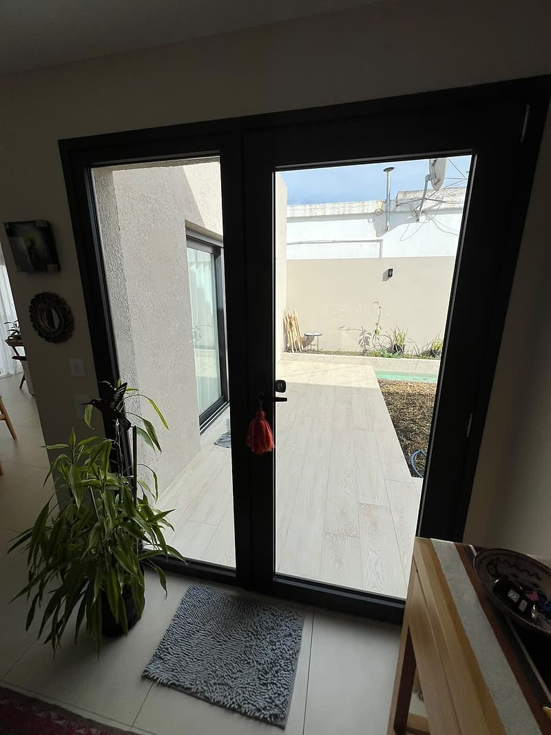 Puerta de dos hojas negra hacia el patio