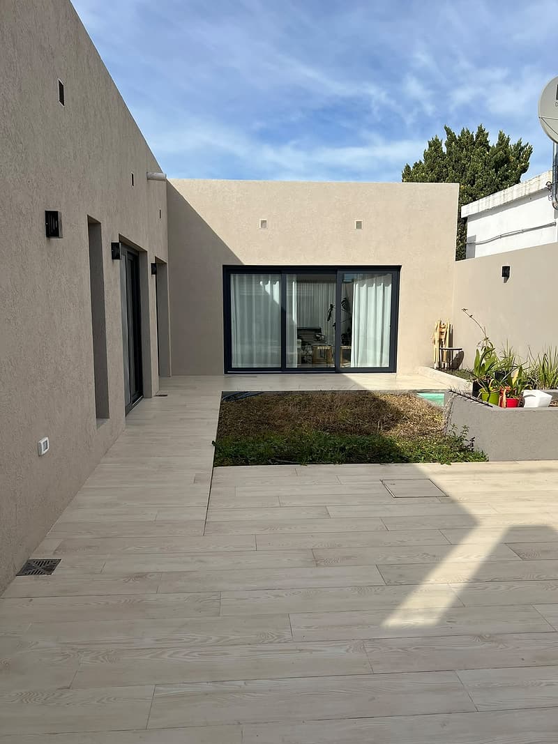 Casa con patio y aberturas corredizas negras